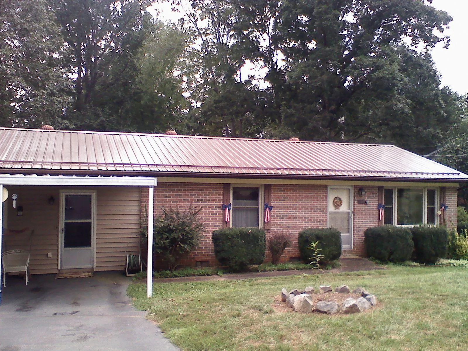 Bronze metal roof and carport on a brick ranch home — Roof Repair work by our crew in Darragh